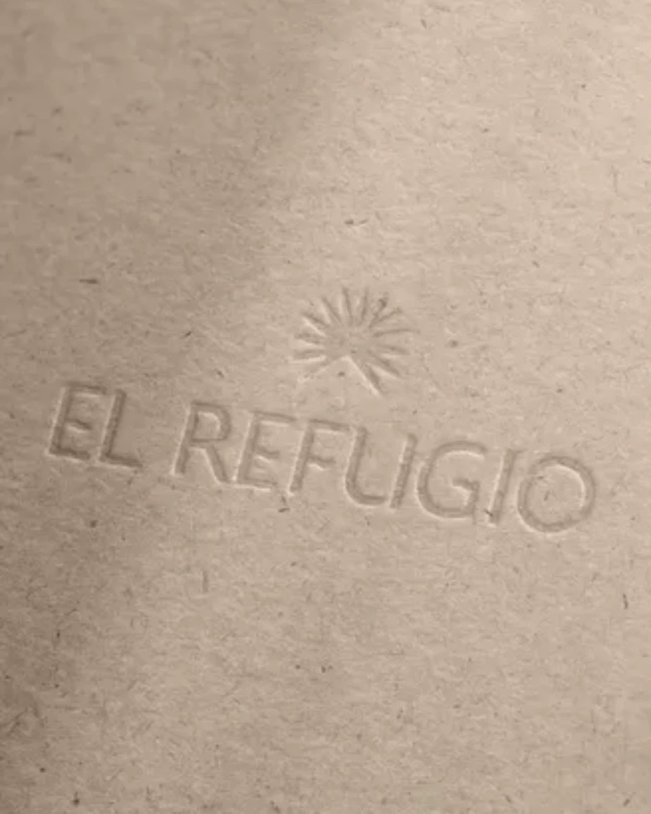 Logotipo de El Refugio en relieve sobre papel